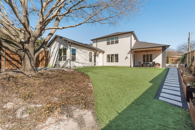 back of house featuring a yard and a fenced backyard