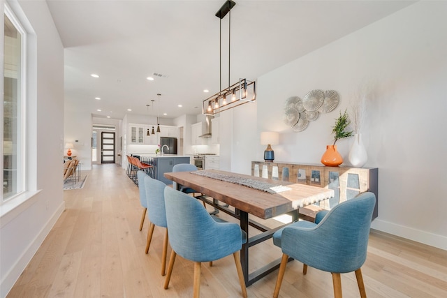 dining space with light wood-style flooring, visible vents, baseboards, and recessed lighting