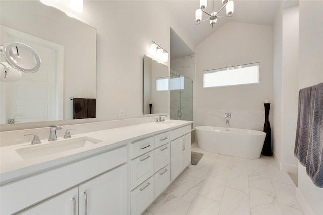 bathroom featuring lofted ceiling, marble finish floor, a sink, and a soaking tub