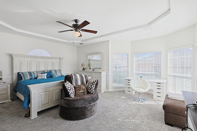 bedroom featuring light carpet, ceiling fan, and a raised ceiling