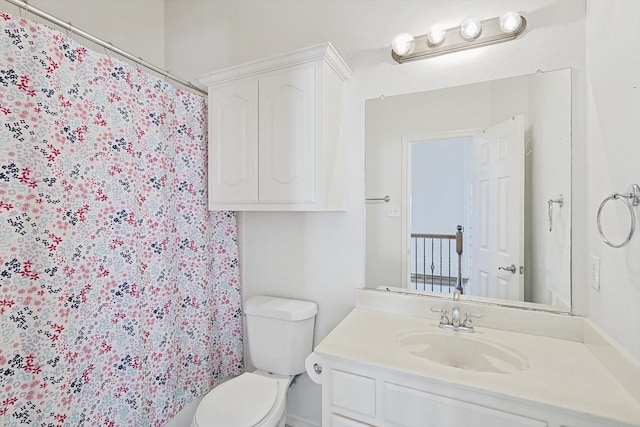 bathroom featuring toilet, curtained shower, and vanity