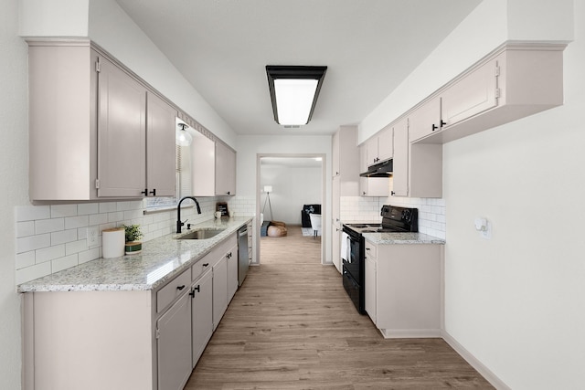 kitchen featuring light wood-style flooring, electric range, stainless steel dishwasher, a sink, and under cabinet range hood