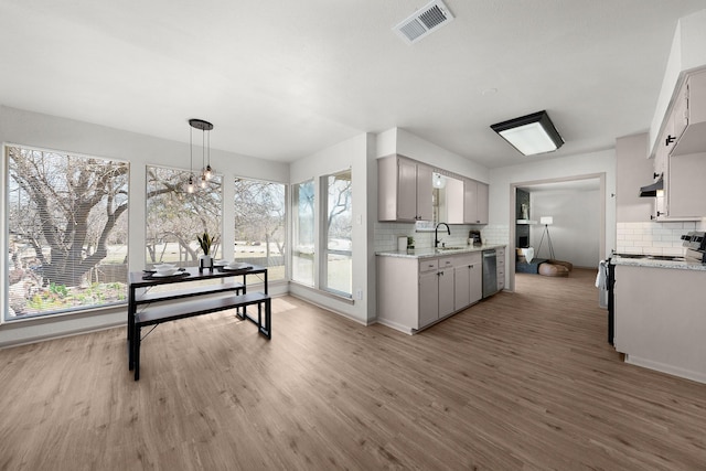 kitchen with hanging light fixtures, visible vents, light countertops, and wood finished floors