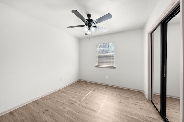 unfurnished bedroom with a closet, light wood-style flooring, and a ceiling fan