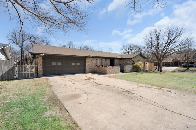 view of front facade with brick siding, fence, a garage, driveway, and a front lawn