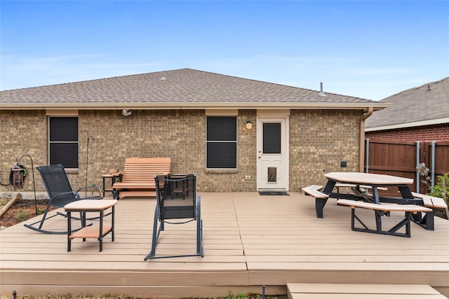 deck with outdoor dining area and fence