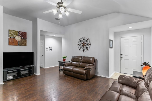 living area featuring vaulted ceiling, wood finished floors, visible vents, and baseboards