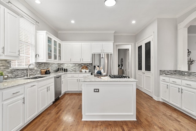 kitchen with white cabinets, a kitchen island, stainless steel appliances, and a sink