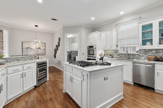 kitchen featuring appliances with stainless steel finishes, wine cooler, a sink, and white cabinetry