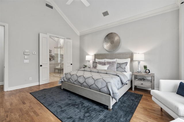 bedroom featuring high vaulted ceiling, wood finished floors, visible vents, baseboards, and ornamental molding