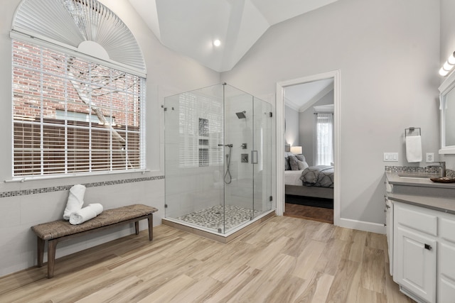 bathroom with lofted ceiling, wood finished floors, ensuite bathroom, vanity, and a shower stall