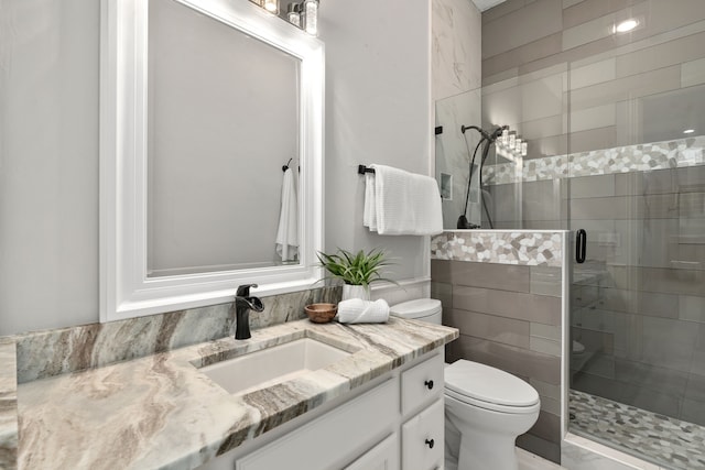 bathroom featuring toilet, a shower stall, and vanity