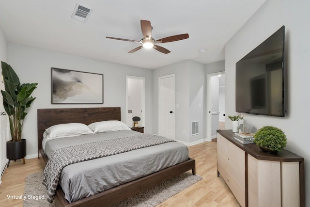 bedroom featuring light wood finished floors, visible vents, and baseboards