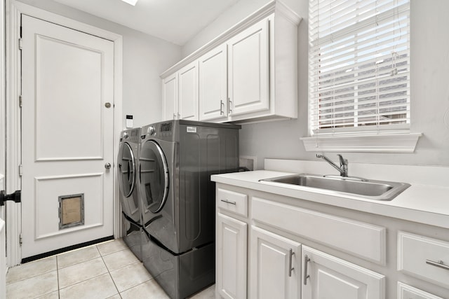 clothes washing area featuring washing machine and dryer, cabinet space, a sink, and light tile patterned flooring