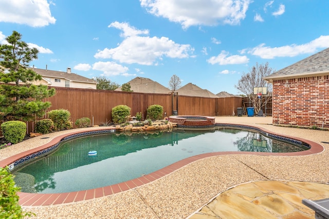 view of pool featuring a patio area, a fenced backyard, and a pool with connected hot tub