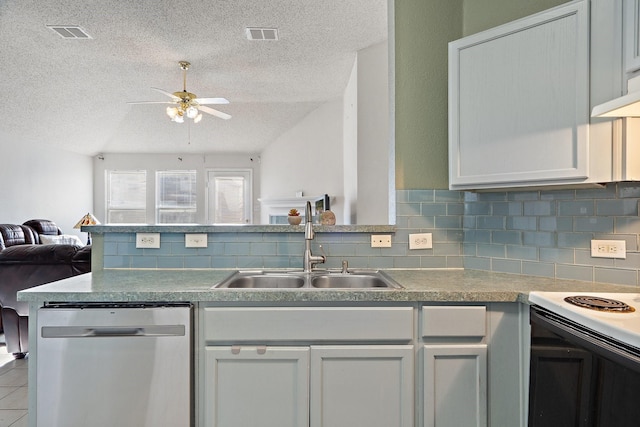 kitchen featuring open floor plan, white cabinets, a sink, dishwasher, and a peninsula