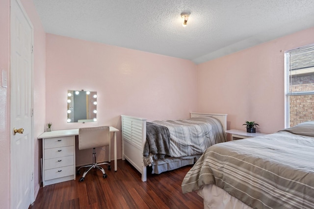 bedroom with a textured ceiling and dark wood-type flooring