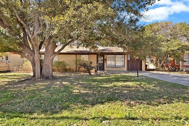 view of front of house featuring an attached garage, driveway, and a front yard