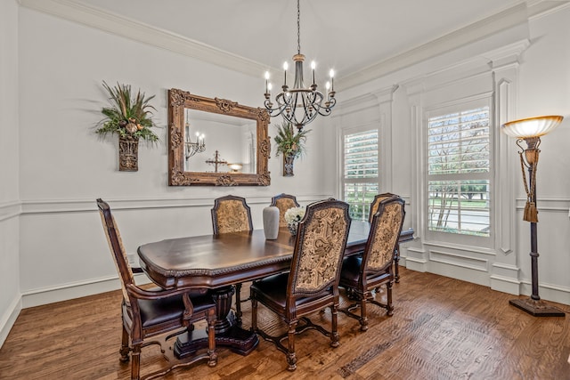 dining area with ornamental molding, a decorative wall, wood finished floors, and a notable chandelier