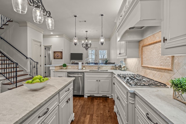 kitchen with appliances with stainless steel finishes, decorative light fixtures, custom exhaust hood, white cabinetry, and a sink