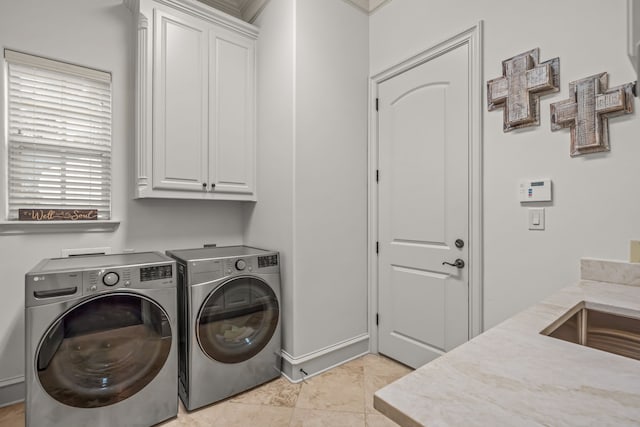 laundry area with washing machine and dryer, cabinet space, and light tile patterned floors