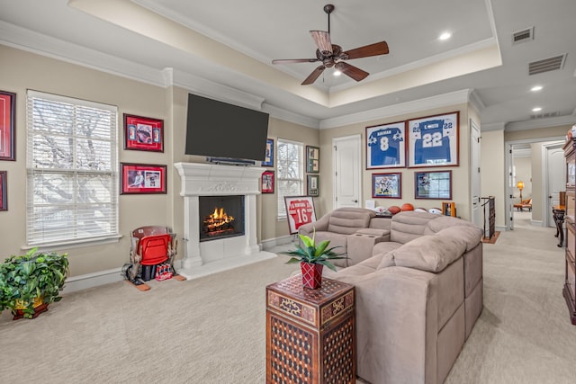 living area with visible vents, a raised ceiling, and light colored carpet