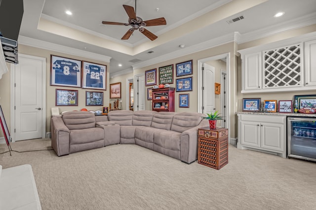 living room with light carpet, beverage cooler, visible vents, a raised ceiling, and a bar