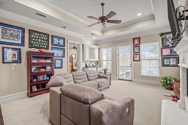 living area featuring light carpet, visible vents, a fireplace, and a tray ceiling