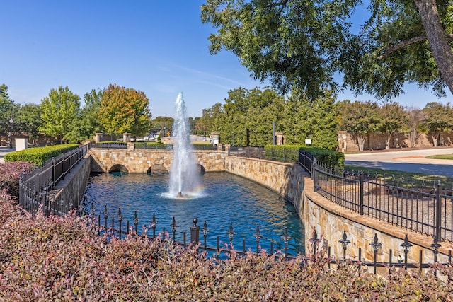 surrounding community featuring a water view and fence