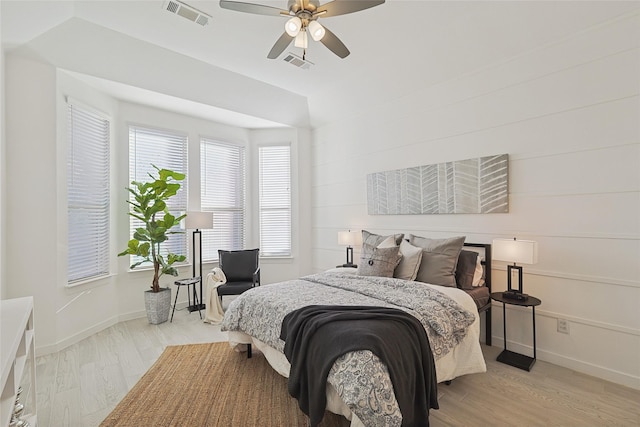 bedroom featuring light wood finished floors, baseboards, visible vents, and ceiling fan