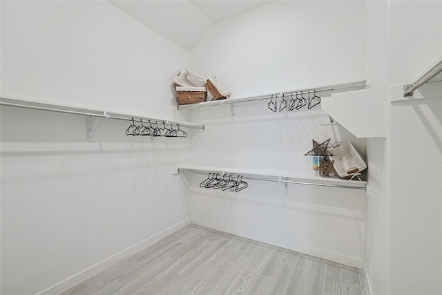 spacious closet featuring vaulted ceiling and wood finished floors