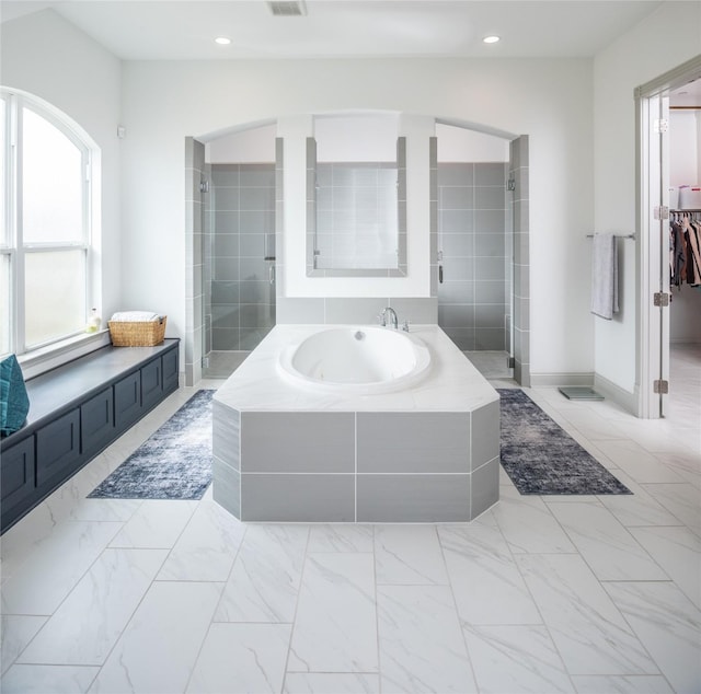 bathroom with a garden tub, a stall shower, and marble finish floor