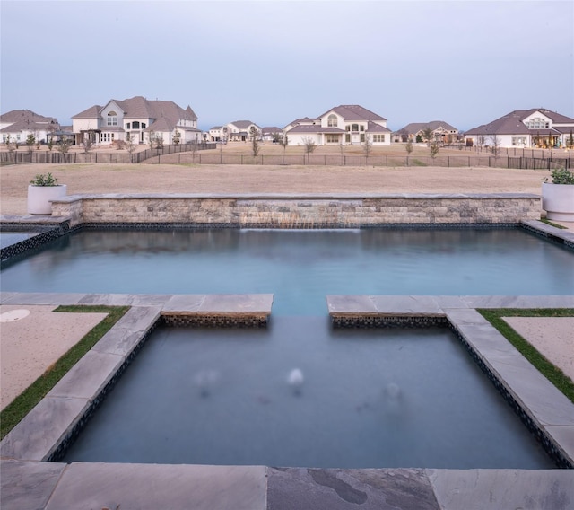 view of swimming pool featuring a residential view and a fenced backyard