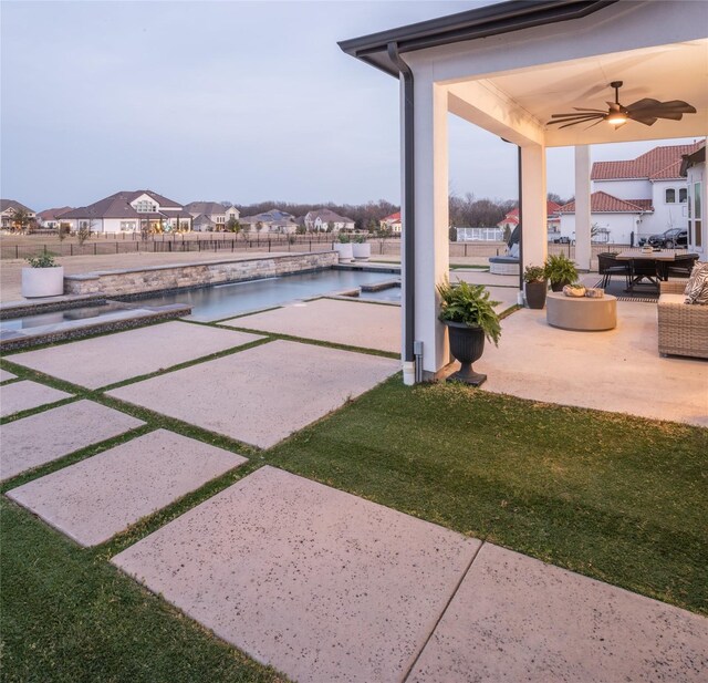 view of patio featuring a residential view, an outdoor pool, ceiling fan, and fence