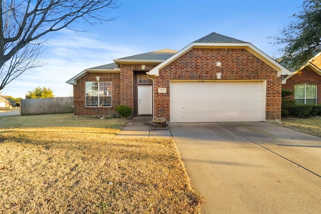 view of front of house with a garage, driveway, brick siding, and fence