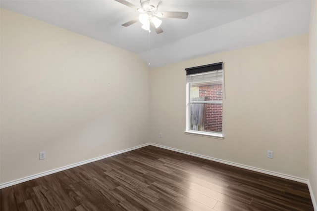 spare room featuring dark wood-style floors, baseboards, vaulted ceiling, and a ceiling fan