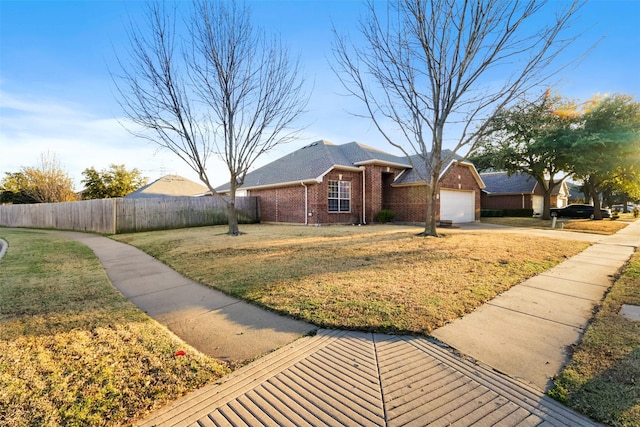 view of front of house with brick siding, concrete driveway, an attached garage, fence, and a front lawn