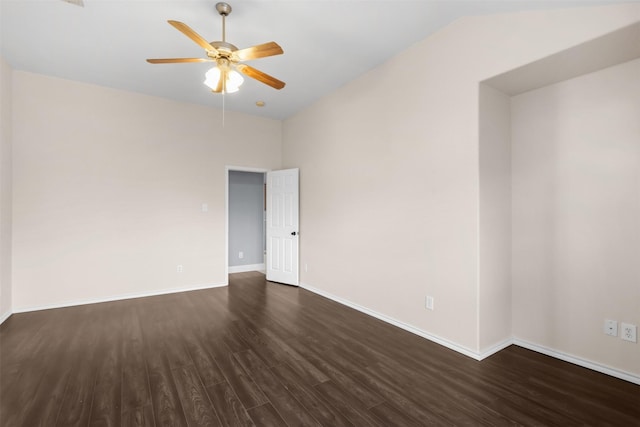 empty room featuring lofted ceiling, ceiling fan, dark wood finished floors, and baseboards