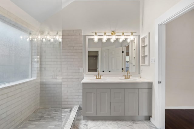 full bathroom featuring lofted ceiling, double vanity, a walk in shower, and a sink