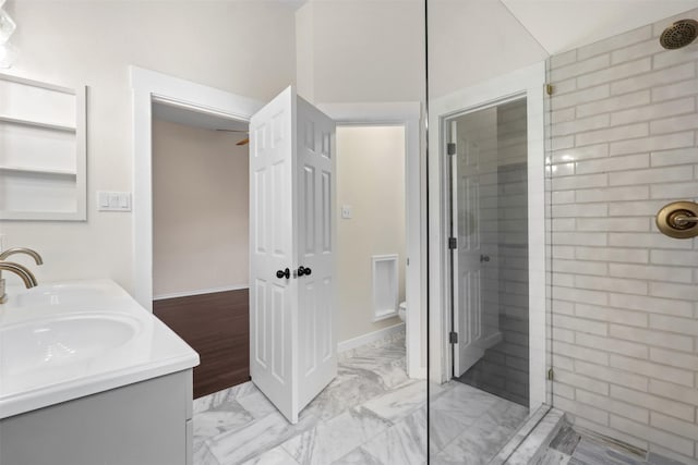 full bathroom featuring double vanity, a stall shower, toilet, marble finish floor, and a sink