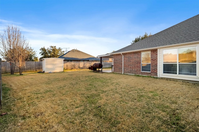 view of yard with a storage shed, an outdoor structure, and a fenced backyard