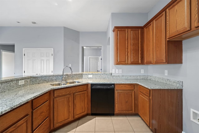 kitchen featuring black dishwasher, brown cabinets, a sink, and light stone countertops