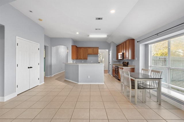 kitchen featuring visible vents, black electric range, light countertops, brown cabinetry, and stainless steel microwave