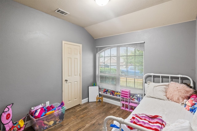 bedroom with vaulted ceiling, dark wood-type flooring, visible vents, and baseboards