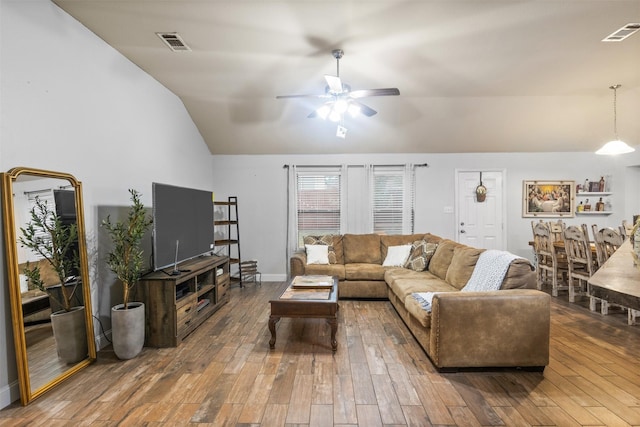 living area with lofted ceiling, wood finished floors, visible vents, and a ceiling fan