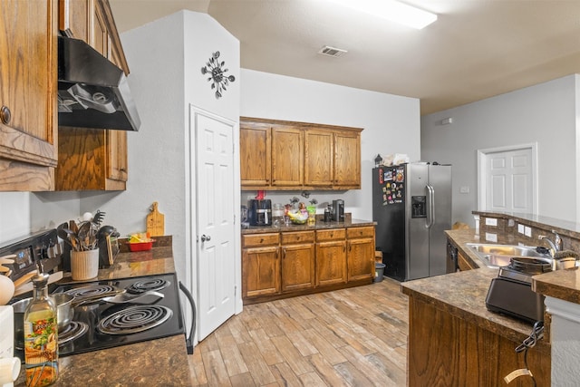 kitchen featuring under cabinet range hood, electric range, dark countertops, and stainless steel fridge with ice dispenser