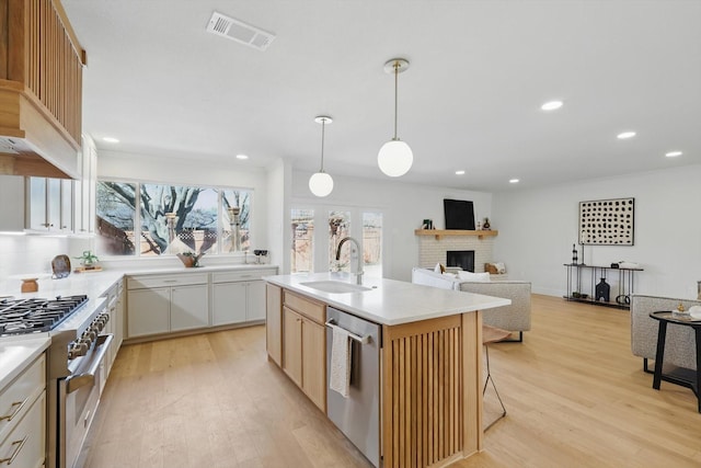 kitchen with stainless steel appliances, a sink, visible vents, white cabinetry, and light countertops