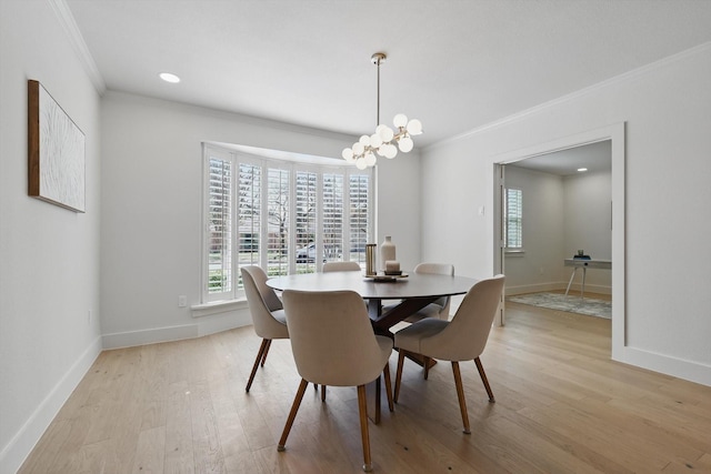 dining area with light wood-type flooring, baseboards, a chandelier, and crown molding