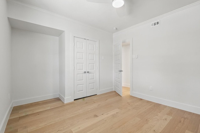 unfurnished bedroom featuring light wood-style floors, baseboards, visible vents, and ornamental molding