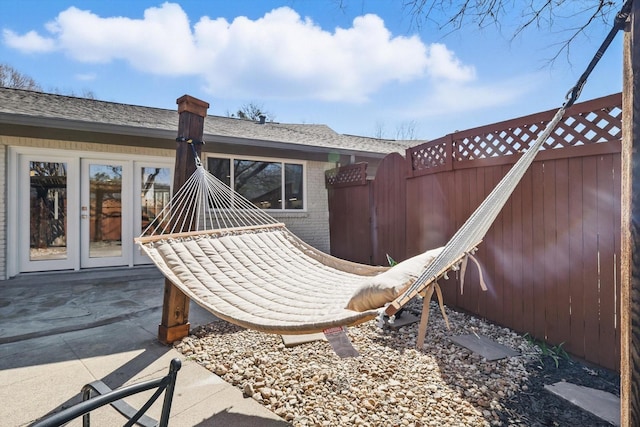 view of patio featuring french doors and fence